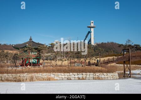 Pyeongchang, Südkorea - 17. Februar 2018: Cheongsong Pavilion auf Pine Island in mit Skisprungschanze im Hintergrund Stockfoto