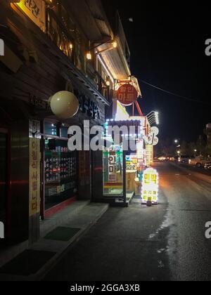 Gangneung, Südkorea - 16. Februar 2018: Beleuchtete Straße mit Restaurants neben dem Gyeongpo Strand in Gangmun-dong, nachts Stockfoto