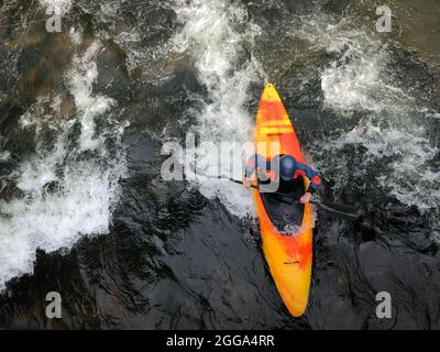 Whitewate Kayaker beim Wellenreiten auf dem Fluss in North Carolina. Stockfoto