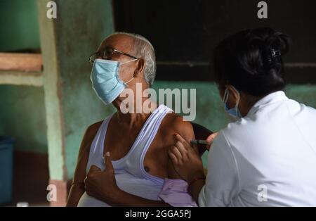 Guwahati, Guwahati, Indien. August 2021. Eine Krankenschwester, die am Sonntag, dem 29. August 2021, einer älteren Person in einem Impfzentrum in Guwahati Assam Indien eine COVID-19-Injektion verabreicht. (Bild: © Dasarath Deka/ZUMA Press Wire) Stockfoto