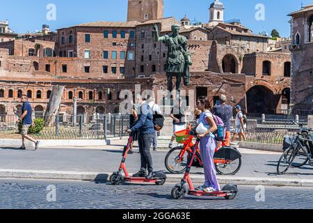 ROM, ITALIEN, GROSSBRITANNIEN. August 2021. Menschen, die an einem heißen Tag in Rom auf der Via dei Fori Imperiali mit einem Elektroroller fahren. Elektroroller sind in der römischen Hauptstadt populär geworden und werden regelmäßig als Mobilitätstransport eingesetzt. Kredit: amer ghazzal/Alamy Live Nachrichten Stockfoto