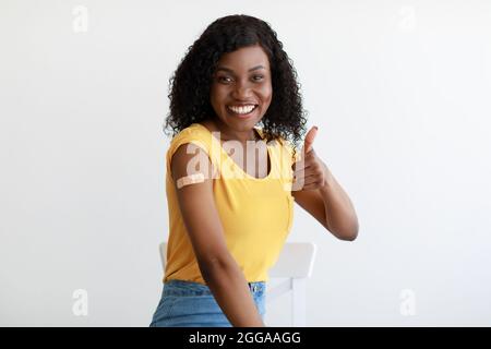 Geimpfte Afrikanische Lady Beim Aufziehen Der Daumen Nach Oben Armimpfung Im Studio Stockfoto