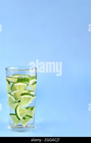Glas mit Wasser und Kalk auf blauem Hintergrund. Stockfoto