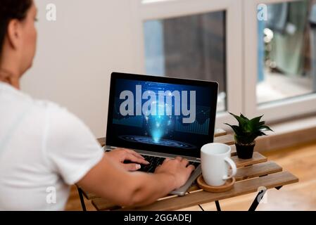 Frau, die ihre Arbeit auf EINEM Laptop neben schönen Pflanzen- und Kaffeebecher arbeitet von zu Hause aus. Girl Making Projects Neben Cup Und Flower Finishing Stockfoto