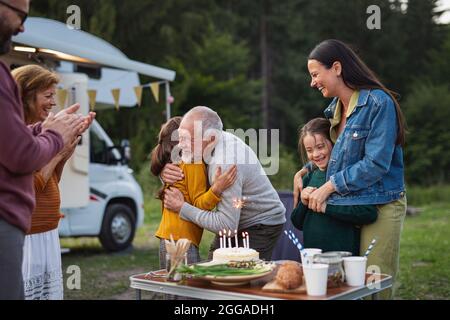 Multi-Generation-Familie feiert Geburtstag im Freien auf dem Campingplatz, Wohnwagen Urlaub Reise. Stockfoto