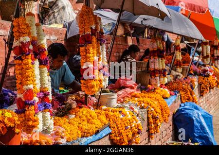 Ringelblumen-Girlande-Verkäufer auf der Treppe des Maju-Dega-Tempels in Kathmandu, Durbar Square, Nepal Stockfoto