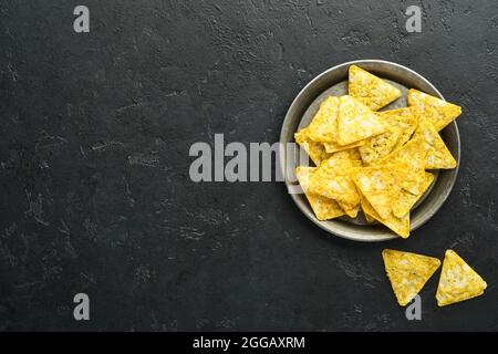 Nachos. Traditionelle lateinamerikanische mexikanische Maischips mit Guacamole-Dip-Sauce in einer schwarzen Schüssel mit Avocado und Zutaten und Mais-Nachos. Avocado sp Stockfoto