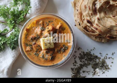 Butterhuhn aus gegrillten Hähnchenstückchen, gekocht in buttrig-cremiger Tomatensoße, serviert mit kerala Parotta, einem geschichteten Fladenbrot aus Maida. Thi Stockfoto