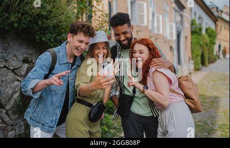 Porträt einer Gruppe junger Menschen im Freien auf einer Reise in die Stadt, Selfie mit dem Smartphone. Stockfoto