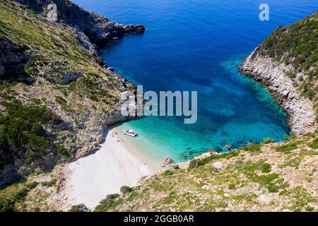 Spektakulärer Strand auf einer einsamen halbinsel von karaburun und Touristen aus der Vogelperspektive, erkunden ihn mit dem Schnellboot, albanien Stockfoto