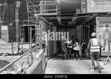 LUSAIL, KATAR - 01. Aug 2018: Eine Graustufen von Arbeitern mit Uniform beim Bau von Gebäuden in Lusail City in Katar Stockfoto