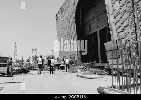 LUSAIL, KATAR - 01. Aug 2018: Eine Graustufe von Arbeitern mit Uniform beim Bau von Gebäuden in Lusail City in Katar Stockfoto