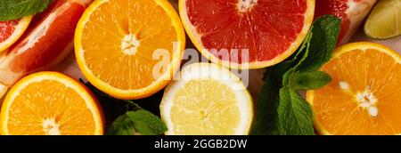 Orange, Zitrone, Grapefruit, Mandarine und Limette auf trendigen rosafarbenen Stein- oder Betontischhintergrund. Zitrusfrüchte. Draufsicht, flach liegend. Stockfoto