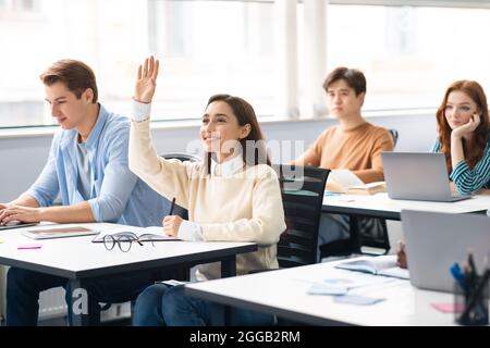 Porträt einer Schülerin, die im Klassenzimmer Hand hebt Stockfoto