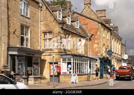 The Stow News and Post Office in der malerischen Marktstadt Stow on the Wold in Cotswold mit traditionellen Kalksteingebäuden. August, England Stockfoto