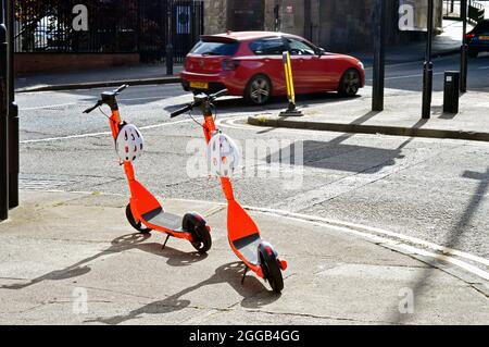 NEWCASTLE. TYNE und WEAR. ENGLAND. 06-24-21. Melbourne Street, zwei Elektroroller auf dem Bürgersteig geparkt. Stockfoto