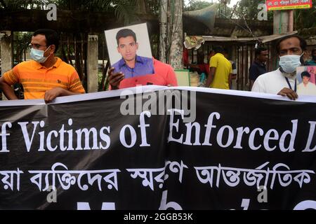 Dhaka, Bangladesch. August 2021. Angehörige halten Portraits ihrer vermissten Familienmitglieder bei einer Veranstaltung der Bangladesh Nationalist Party am Internationalen Tag der Opfer erzwungener Verschwindenlassen in Dhaka, Bangladesch, am 30. August 2021. Kredit: Mamunur Rashid/Alamy Live Nachrichten Stockfoto