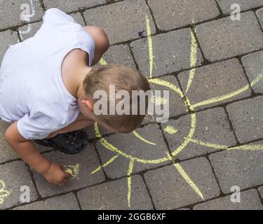 Schöne Ansicht von oben nach unten auf Kinderzeichnungen mit Kreide auf Pflasterplatten. Stockfoto