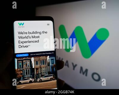 Person, die Mobiltelefon mit der Webseite des US-Autonomous Driving Company Waymo LLC auf dem Bildschirm vor dem Logo hält. Konzentrieren Sie sich auf die Mitte des Telefondisplays. Stockfoto