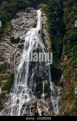 Enger Wasserfall, bewegtes Wasser, Kaskadierung, Felswand, Natur, Power, grüne Vegetation, Milford Sound, Fiordland National Park, Te Anau, Neuseeland Stockfoto