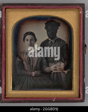 Ohne Titel (Portrait of Two Women), 1848. Schwarz-Weiß-Porträtfoto in einer goldenen Matte und Rahmen von zwei jungen Frauen: Eine sitzende weiße Frau links und eine stehende schwarze Frau rechts. Die weißen Frauen erreichen ein klares Glas auf einem Tablett, das von der schwarzen Frau gehalten wird. Stockfoto