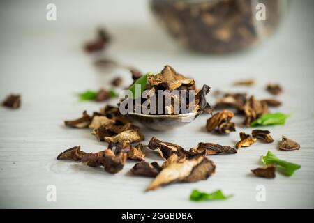 Getrocknete Waldpilze auf einem hellen Holztisch Stockfoto
