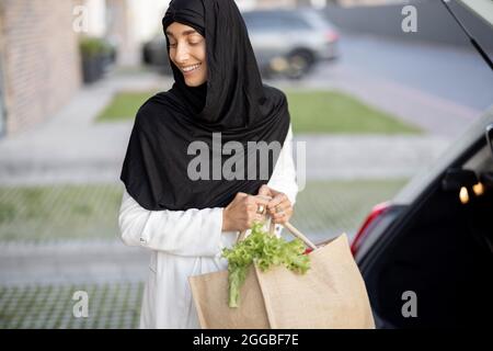Muslimische Frau, die mit Lebensmitteln nach Hause kommt Stockfoto