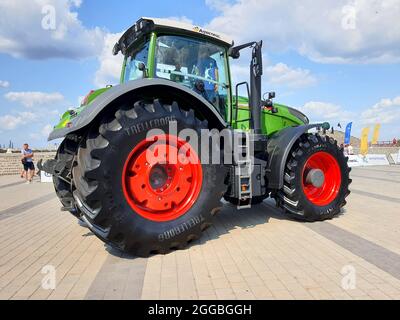Großer roter landwirtschaftlicher Traktor mit riesigen Rädern auf dem Display auf der Ausstellung, Traktorreifen in der Stadt Dnipro, Dnepropetrovsk, Ukraine. 2021-07-24 Stockfoto