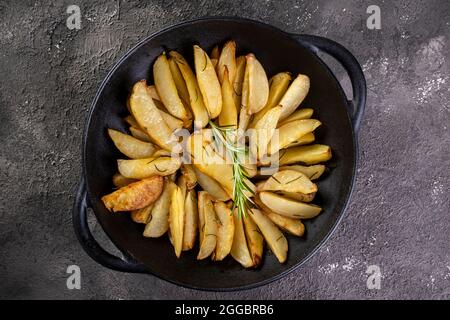 In Eiserne Kasserolle gebackene Kartoffeln mit Rosmarin und Olivenöl. Stockfoto