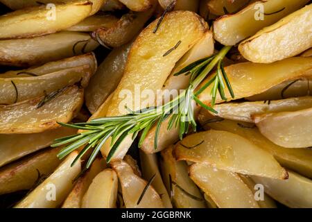 Nahaufnahme von gebackenen Kartoffeln mit Rosmarinzweig. Stockfoto