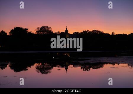 Ein Kirchturm spiegelt sich im Lake of the Isles, Minneapolis, Minnesota, USA Stockfoto