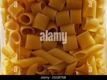 Nudeln in einem Glas vermischen. Mezze Maniche und Penne Pasta Stockfoto