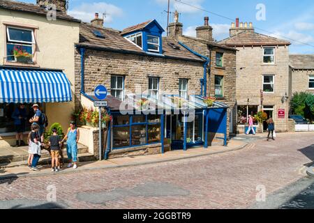 HAWES, Großbritannien - 23. AUGUST 2021: Hawes ist eine Marktstadt im Herzen von Yorkshire Dales mit Steingebäuden, Geschäften und Häusern, die durch gepflasterte Straßen miteinander verbunden sind Stockfoto