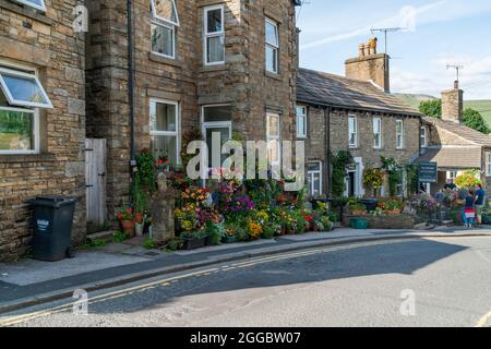 HAWES, Großbritannien - 23. AUGUST 2021: Hawes ist eine Marktstadt im Herzen von Yorkshire Dales mit Steingebäuden, Geschäften und Häusern, die durch gepflasterte Straßen miteinander verbunden sind Stockfoto