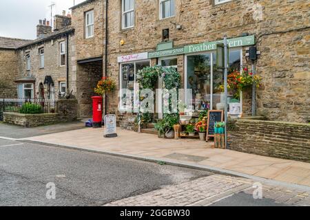 HAWES, Großbritannien - 23. AUGUST 2021: Hawes ist eine Marktstadt im Herzen von Yorkshire Dales mit Steingebäuden, Geschäften und Häusern, die durch gepflasterte Straßen miteinander verbunden sind Stockfoto