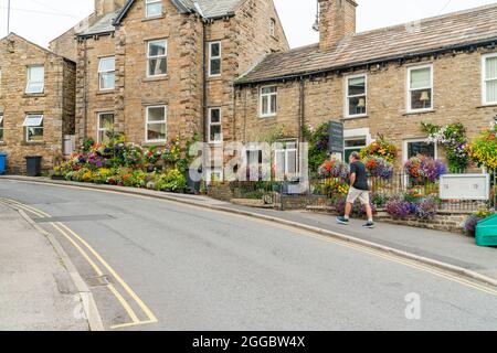 HAWES, Großbritannien - 23. AUGUST 2021: Hawes ist eine Marktstadt im Herzen von Yorkshire Dales mit Steingebäuden, Geschäften und Häusern, die durch gepflasterte Straßen miteinander verbunden sind Stockfoto