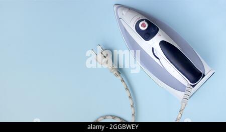 Bügeleisen zum Bügeln auf blauem Hintergrund. Draufsicht, Kopierbereich Stockfoto