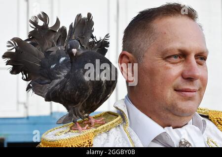 Kramatorsk, Ukraine. August 2021. Der Zeremonienmeister (MC) sah mit seiner Taube vor der Kramatorsker Zeltshow stehen. Traditionelle Zeltshows sind im 21. Jahrhundert bei ukrainischen Menschen jeden Alters immer noch sehr beliebt. Kredit: SOPA Images Limited/Alamy Live Nachrichten Stockfoto
