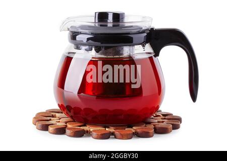 Teekannen aus Glas mit Tee auf einem Holzständer, isoliert auf Weiß Stockfoto
