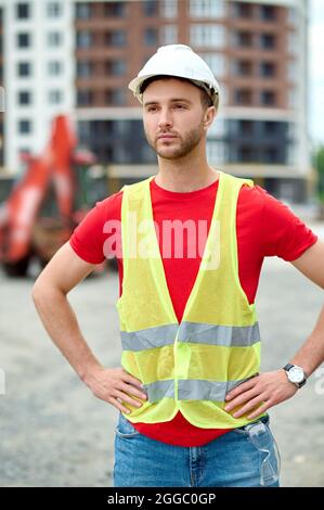 Arbeiter in einer Sicherheitsweste und einem Helm, der im Freien steht Stockfoto