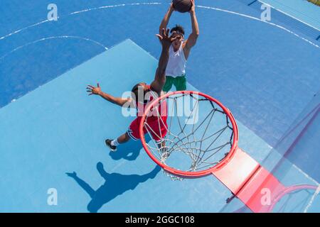 Blick von oben auf multiethnische Sportler, die auf dem Spielplatz Streetball spielen Stockfoto