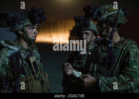 Fallschirmjäger, die dem Kampfteam der 1. Brigade, der 82. Luftlandedivision, zugewiesen sind, erhalten einen Schichtwechsel, bevor sie die Kontrolle über einen Kontrollpunkt am Hamid Karzai International Airport in Kabul, Afghanistan, übernehmen, 25. August 2021. Die 82. ABN. Div. Unterstützt weiterhin die sichere Evakuierung von US-Bürgern, Visa für Sondereinwanderer und anderen gefährdeten Afghanen aus Afghanistan so schnell und sicher wie möglich. (USA Foto der Armee) Stockfoto