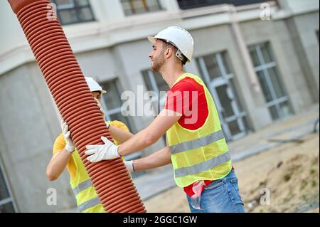 Facharbeiter, die eine Abwasserkanalleitung für Wohngebäude installieren Stockfoto