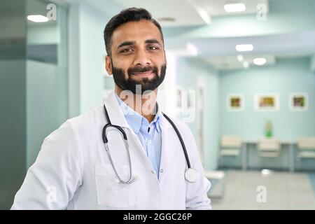 Porträt eines indischen Arztes, der im Klinikkrankenhaus steht und die Kamera anschaut. Stockfoto