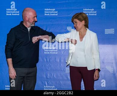 Edinburgh, Schottland, Großbritannien, 30. August 2021. Edinburgh International Book Festival: Im Bild: Die erste Ministerin Nicola Sturgeon und Douglas Stuart, Gewinner des Booker-Preises, beim Buchfestival, bei einem Ellenbogengruß Stockfoto