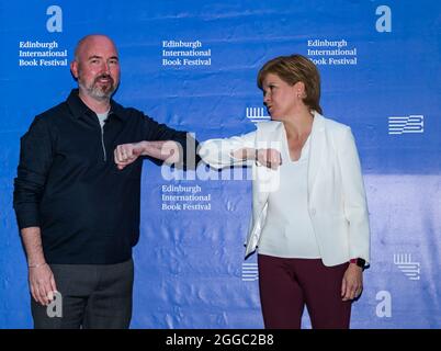 Edinburgh, Schottland, Großbritannien, 30. August 2021. Edinburgh International Book Festival: Im Bild: Die erste Ministerin Nicola Sturgeon und Douglas Stuart, Gewinner des Booker-Preises, beim Buchfestival, bei einem Ellenbogengruß Stockfoto