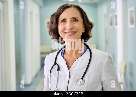 Lächelnd Frau glücklich Arzt Kinderarzt im Klinikkrankenhaus stehen. Hochformat. Stockfoto