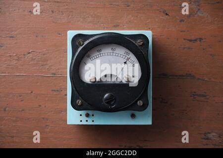 Altes analoges Voltmeter mit einem Metallpfeil. Messung der Spannung im elektrischen Netz. Stockfoto