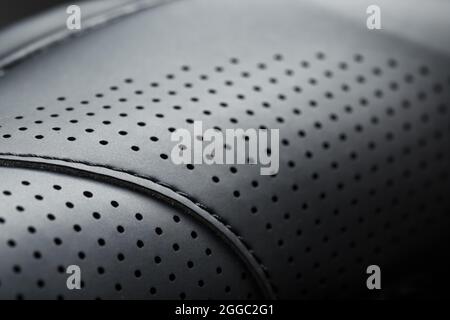 Perforiertes Material aus schwarzem Lederimitat im Vollbildmodus. Nahaufnahme Stockfoto