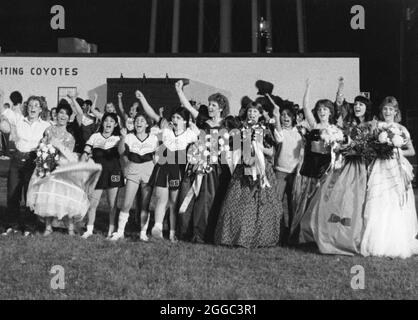 Uvalde Texas USA: Teenager-Mädchen, die Ballkleider tragen und Blumensträuße halten, werden während der Halbzeitzeremonie ihrer High School als Homecoming Queen und als Zuschauerin auf dem Fußballfeld geehrt. ©Bob Daemmrich Stockfoto